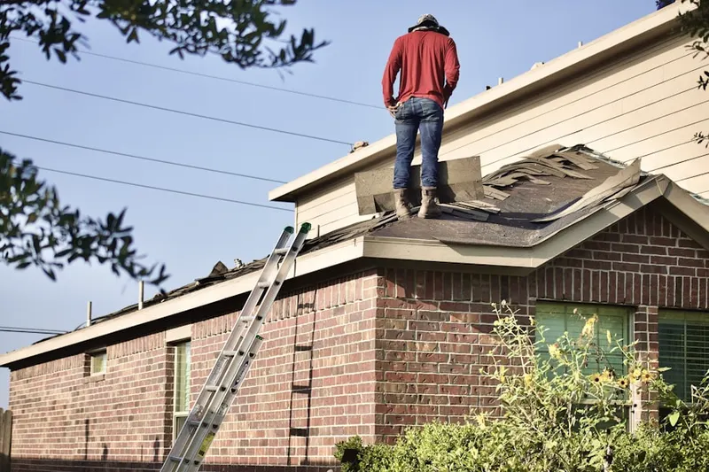 Professional roofer working on a residential roof in Hamer
